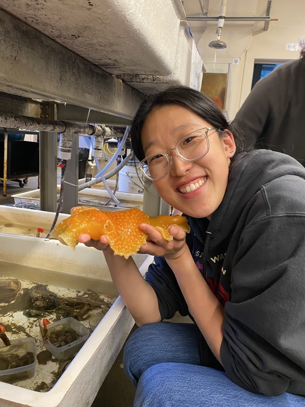 Photo of Stephanie Zhu holding up a starfish