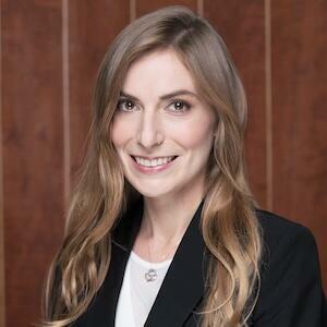 Headshot of Mikela Ritter in front of a wood panel background