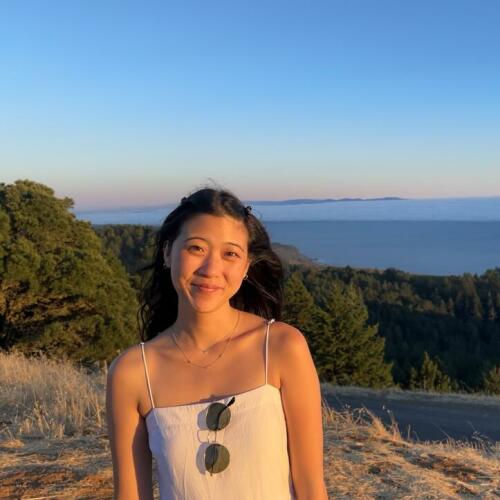 Photo of Christine Chang outside with the ocean in the distance