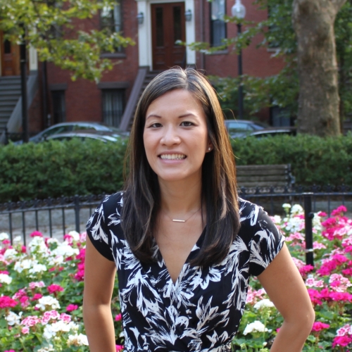 Halfshot of Angela with trees and flowers in the background